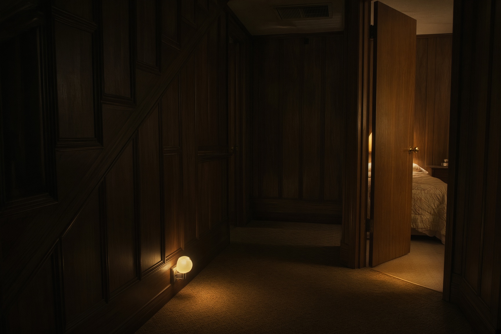 A 1970s wood-paneled hallway at night, a bedroom door ajar, warm light beyond
